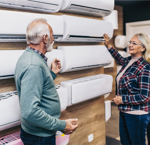 Two people looking at AC units