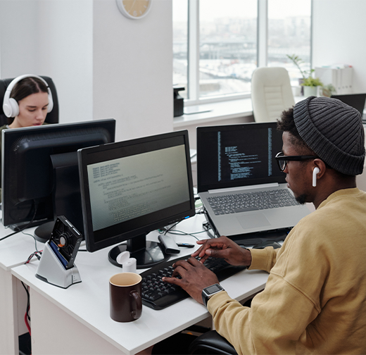 Two people sitting at a desk using computers