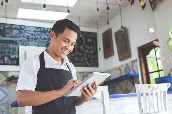 Man in restaurant holding tablet